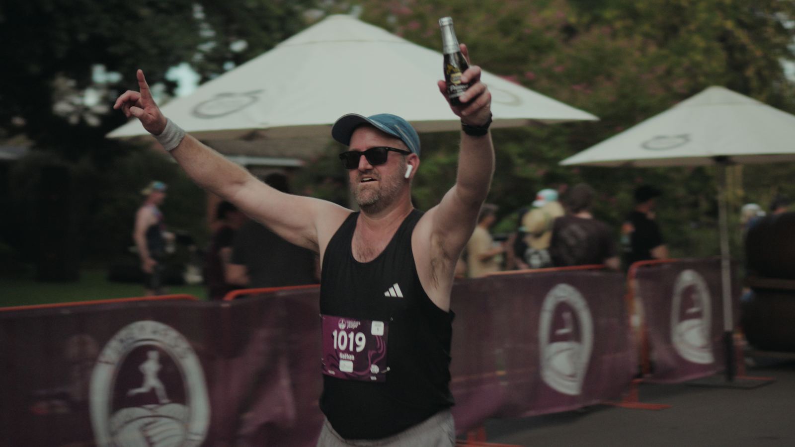 Finisher celebrating with a drink at the finish line
